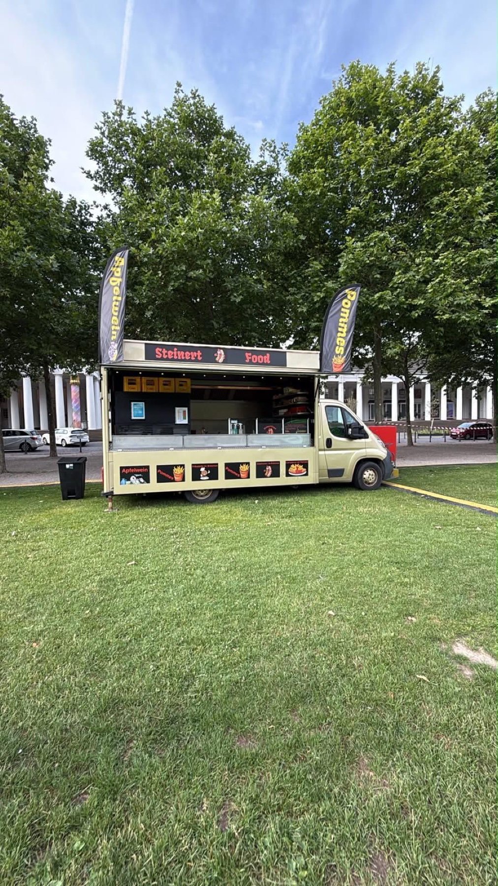 Mobiler SteinertFood Foodtruck auf einer Veranstaltungsfläche im Grünen.